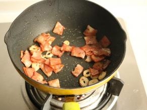 炒锅放少许底油润锅，培根和蒜片放入煸炒出香味，培根变焦香。