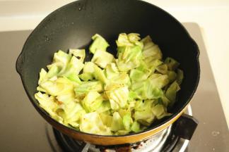 下入甘蓝菜炒软。加一点点盐给甘蓝菜调味。