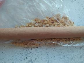 将花生放在保鲜袋中，用擀面杖压碎。