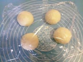 将面团取出，排气，分成四份，揉圆，盖保鲜膜松弛15分钟 