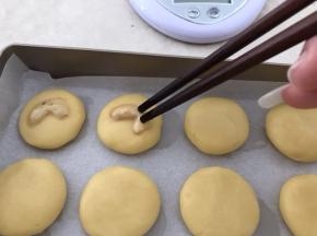 腰果仁一颗掰开成二，沾一下蛋液，这样烤好腰果不易掉
腰果轻轻摁在小饼中间