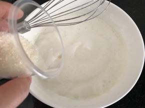 打发至泡沫变细腻时加入第二次白糖，继续打发