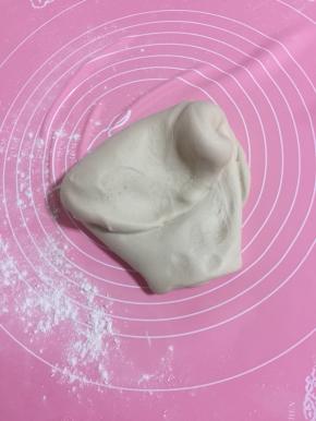 面板上撒少许面粉，发酵好的面团取出来排气，使劲儿揉大约200下左右！（面团揉的越久做出来的包子表面越光滑！）