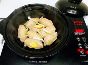 锅烧热，把鸡翅先煎黄再翻面，加入葱，姜（煎出油份后吃着不会觉得腻