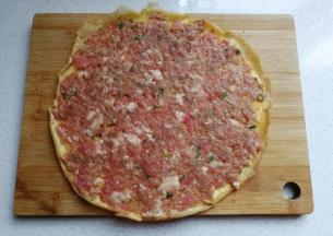 取一张蛋皮，放入适量肉馅用刮刀抹平；