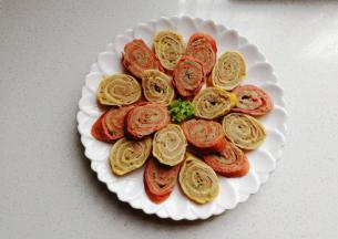 蒸好的蛋卷肉放凉后切片摆盘，然后再回蒸一下，可以原味食用，也可以依个人口味淋上自制味汁食用。