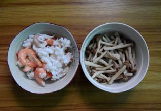 将鱿鱼和虾放沸水焯几秒捞出，蟹味菇去掉根部洗净焯水