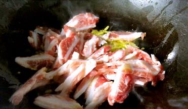 放入腌制好的猪脆骨，炒至断生出香味