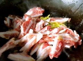 放入腌制好的猪脆骨，炒至断生出香味