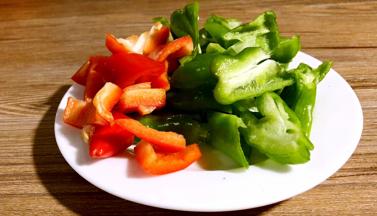 青椒和红椒洗净，去蒂去籽，切成块