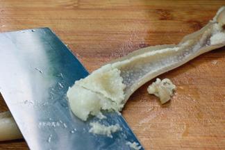 捞起猪皮，在凉水下浸泡片刻，将猪皮另一面的肥油刮干净后切片，就可以搭配其他食材烹调了