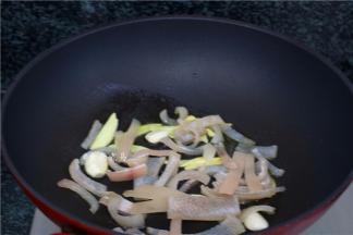 热锅，倒入食用油，将生姜、蒜瓣、猪皮爆香