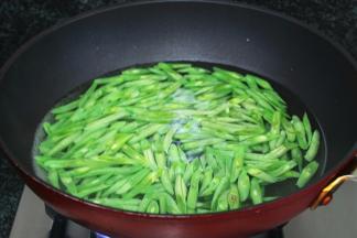 烧开适量水，将四季豆倒入锅中，焯煮软透