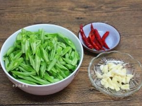 四季豆撕去两边的老筋，洗净，切斜刀段、蒜瓣去皮拍碎、辣椒摘洗净