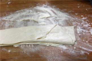 用擀面杖将面团擀薄、面皮两面抹一些干面粉，防止粘连，将擀好的面皮重叠起来