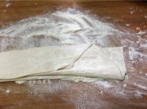 用擀面杖将面团擀薄、面皮两面抹一些干面粉，防止粘连，将擀好的面皮重叠起来