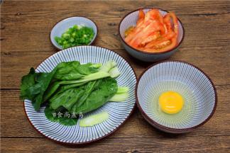 准备配菜：番茄洗净、去皮切片，小白菜洗净切段，小葱洗净切碎，鸡蛋打散