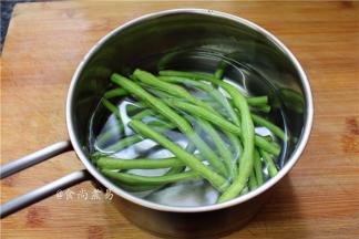 豆角洗净折成长段，撕去筋丝，放入锅中焯熟后捞起，切粒