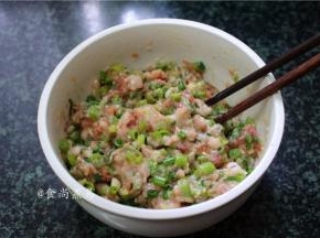 将豆角粒和葱花倒入肉糜中、充分搅拌均匀，调好的馅料放在一旁待用