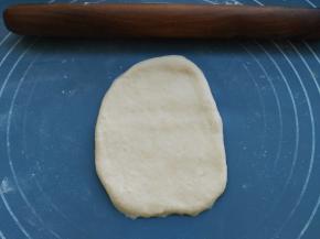 排气结束开始制作，取一个小剂子用擀面杖擀成长条状，如图