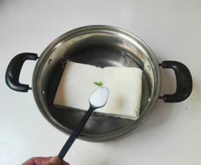 豆腐放进汤锅里，放适量清水，放一勺盐煮开