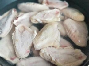 首先将鸡翅洗干净，再焯水，冷水入锅，大火烧开，1分钟即可捞出。捞出后立即过冷水，反复冲洗，将鸡翅的杂质冲洗干净。