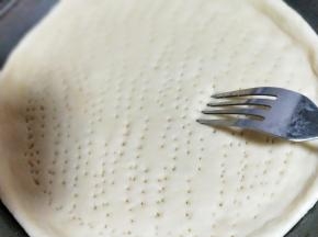 用叉子扎满洞洞，防止饼皮烤的过程中，中间凸起。放入烤箱进行二次发酵约15分钟左右。