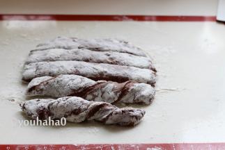 面团上面撒干粉，再次将面团压扁，基本成长方形；用刮板切成差不多大小的5份，用手捏住面团的2端，反向扭起