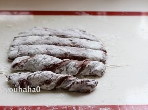 面团上面撒干粉，再次将面团压扁，基本成长方形；用刮板切成差不多大小的5份，用手捏住面团的2端，反向扭起