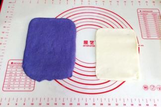 取一份松弛好的面团，用手拍扁，用擀面杖把面团擀开，翻面再擀会，用手整理成长方形，压薄底边。取一份麻薯，继续用擀面杖擀成比面片小点的长方形。l