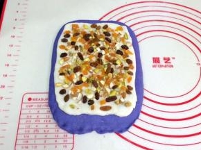把擀开的麻薯片铺在面片上，放上切好的核桃仁、杏仁、开心果、葡萄干和杏仁，然后轻轻按压下。