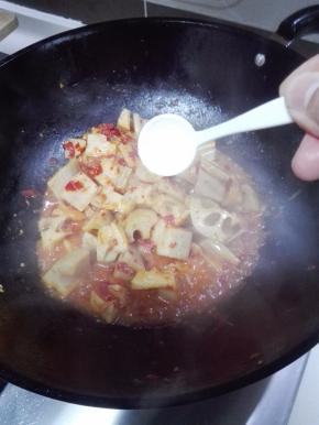 添加少许的清水后，放入一小勺白糖炒匀