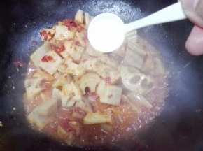 添加少许的清水后，放入一小勺白糖炒匀