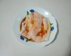 取出三文鱼骨，夹去葱姜片，放一勺生抽