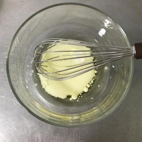 将玉米油和牛奶倒入大碗中，用手动打蛋器搅拌均匀。