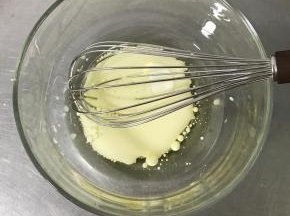 将玉米油和牛奶倒入大碗中，用手动打蛋器搅拌均匀。