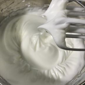 蛋清中加入几滴白醋，分3次加入细砂糖，打发至硬性发泡。平均分成两份。