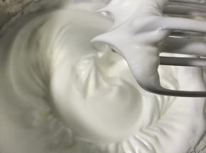 蛋清中加入几滴白醋，分3次加入细砂糖，打发至硬性发泡。平均分成两份。