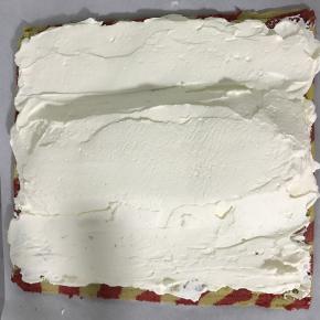 蛋糕卷两边斜切，抹上淡奶油，中间厚两边薄，将两边油纸向中间拎起，在用手辅助整成O型卷。包好油纸放入冰箱冷藏半个小时以上定型。