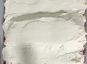 蛋糕卷两边斜切，抹上淡奶油，中间厚两边薄，将两边油纸向中间拎起，在用手辅助整成O型卷。包好油纸放入冰箱冷藏半个小时以上定型。