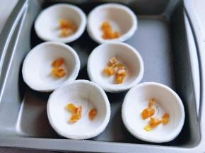 将切好的芒果干丁放入蛋挞皮中。