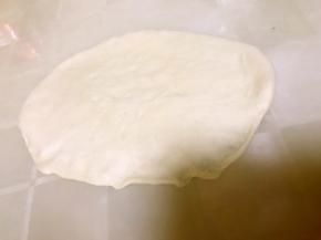 拿出面团擀成牛舌状，接口处按薄