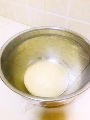 把面团底部收圆，放入盘里，盖上保鲜膜室温发酵60-90分钟至两倍大