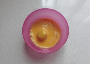 取一份小面团放入蛋液中滚一圈；