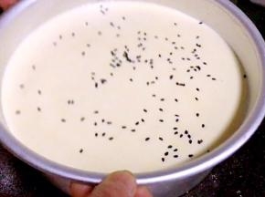 再倒入剩下的蛋糕糊，撒上黑芝麻，轻震几下，排气