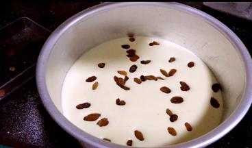 倒入一半到八寸蛋糕模具里，撒上葡萄干