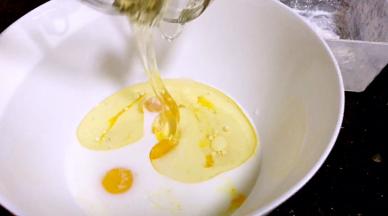 蛋黄里加入牛奶、玉米油和蜂蜜划拌均匀（不要转圈）