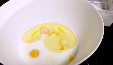 蛋黄里加入牛奶、玉米油、白糖用手动打蛋器划拌均匀