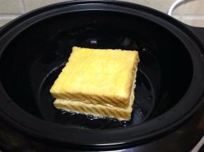 将沾好蛋液的吐司夹摆放在锅内煎制