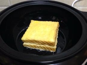 将沾好蛋液的吐司夹摆放在锅内煎制